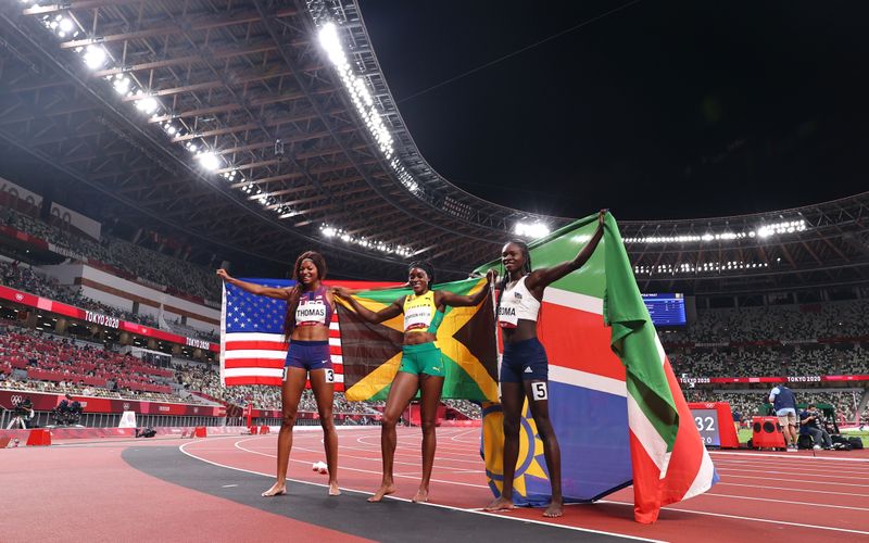 &copy; Reuters.  ８月３日に行われた東京五輪の陸上女子２００メートル決勝で、エレーン・トンプソンヘラ（ジャマイカ）が２１秒５３で金メダルを獲得した。写真はメダルを取った３人。中央がトンプ