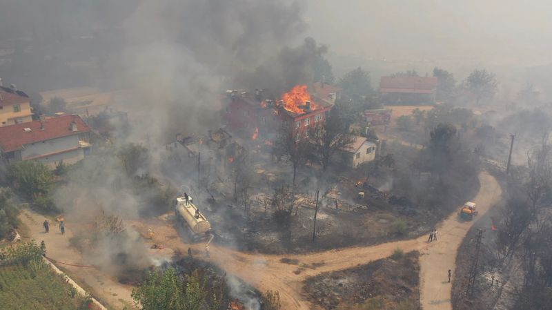 &copy; Reuters. صورة من لقطات فيديو لمنزل يحترق يما يسعي الناس لاحتواء حريق في إقليم اسبرطة في تركيا يوم الاثنين.
(صورة لرويترز من مواقع التواصل الاجتماعي و