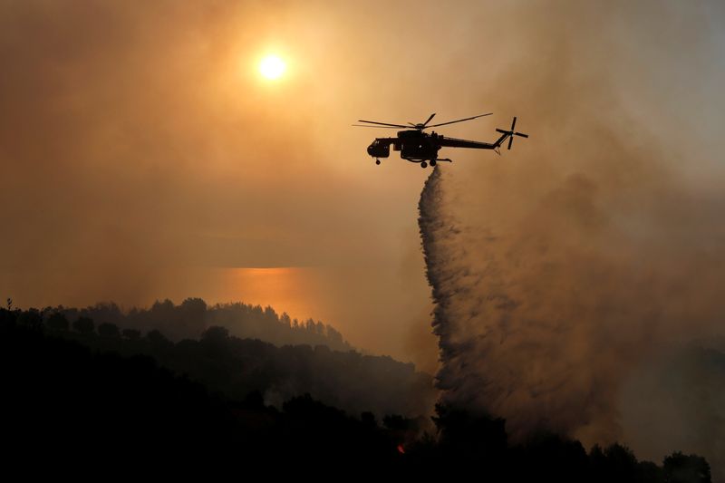 &copy; Reuters. FOTO DE ARCHIVO. Un helicóptero de bomberos realiza un lanzamiento de agua mientras un incendio forestal arde cerca del pueblo de Ziria, cerca de Patras, Grecia. 1 de agosto de 2021. REUTERS/Costas Baltas