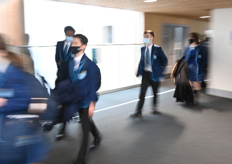 &copy; Reuters. FILE PHOTO: Year 9 students wear protective face masks as they walk between classrooms on the first day back at school, as the coronavirus disease (COVID-19) lockdown begins to ease at Harris Academy Sutton, south London, Britain, March 8, 2021. REUTERS/T