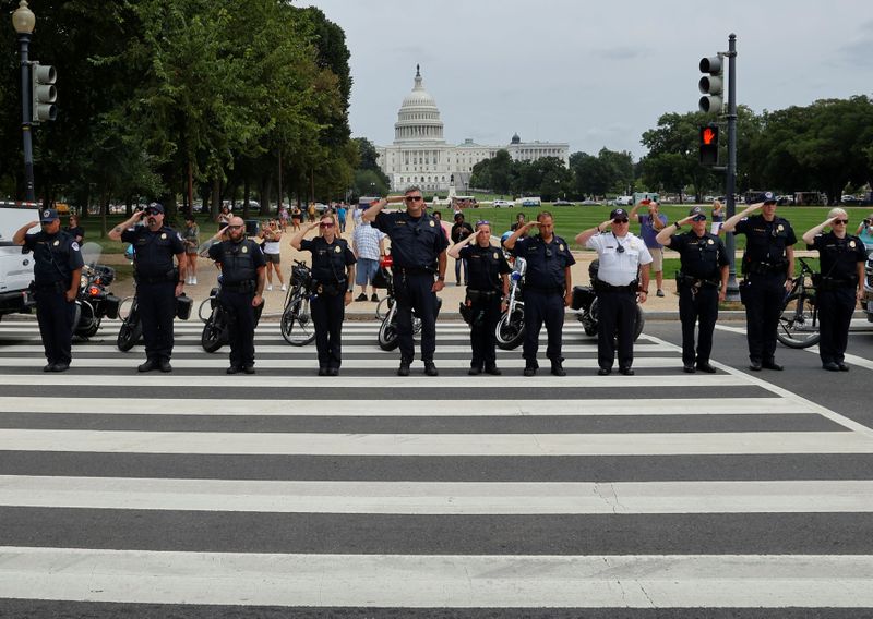 &copy; Reuters. Law enforcement officers from Washington's Metropolitan Police Department, the U.S. Capitol Police, the Pentagon Force Protection Agency and other police departments salute as a ceremonial procession in honor of a police officer wounded in a shooting at t