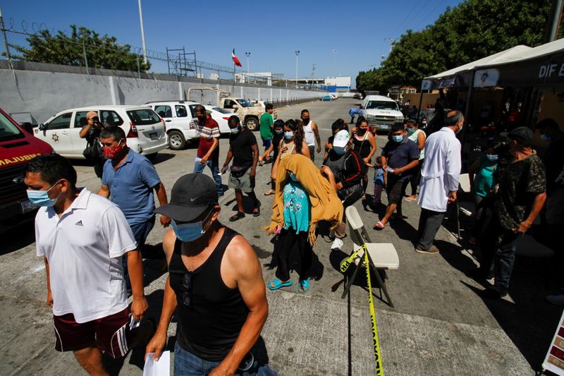 &copy; Reuters. Migrants camping at the El Chaparral border port of entry with the U.S. leave a vaccination point after receiving a dose of the Pfizer BioNTech coronavirus disease (COVID-19) vaccine, amid Republican criticism that the Delta variant is spreading in southe