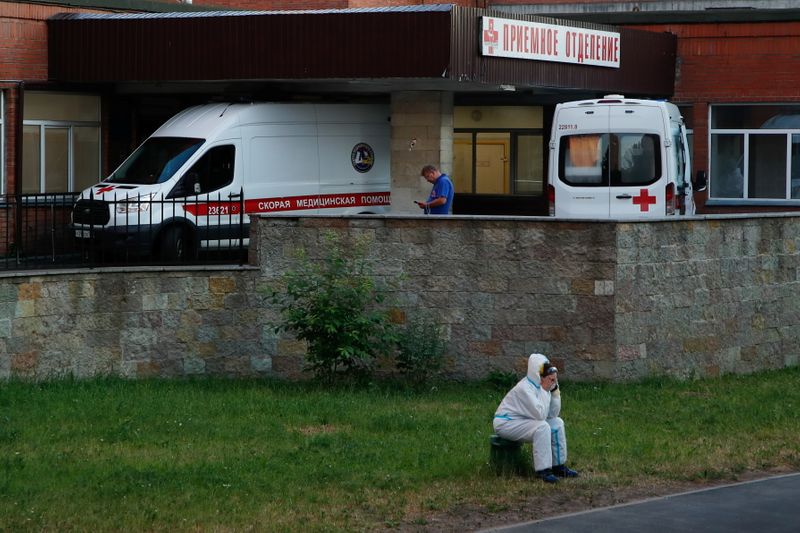 &copy; Reuters. FILE PHOTO: A medical specialist wearing protective gear sits near ambulances parked at the Pokrovskaya hospital amid the outbreak of the coronavirus disease (COVID-19) in Saint Petersburg, Russia June 24, 2021.  REUTERS/Anton Vaganov