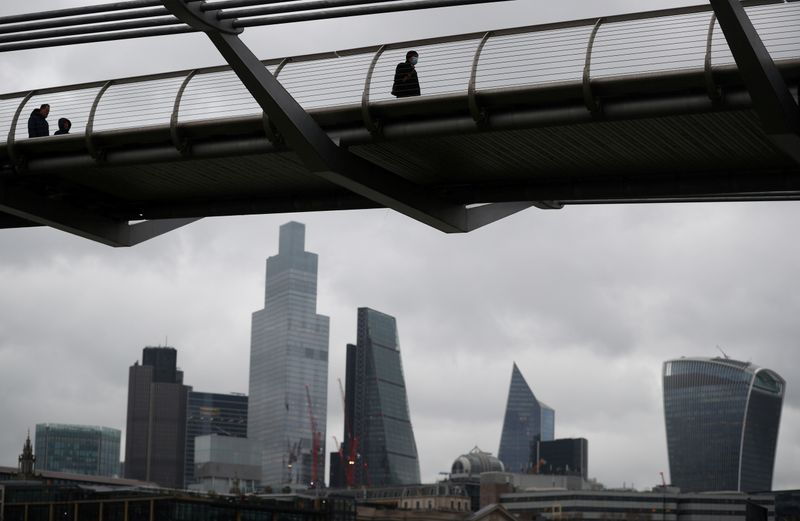 &copy; Reuters. FILE PHOTO: People walk across Millennium Bridge with the City of London financial district seen behind, amid the coronavirus disease (COVID-19) pandemic, in London, Britain, January 20, 2021. REUTERS/Hannah McKay/File Photo