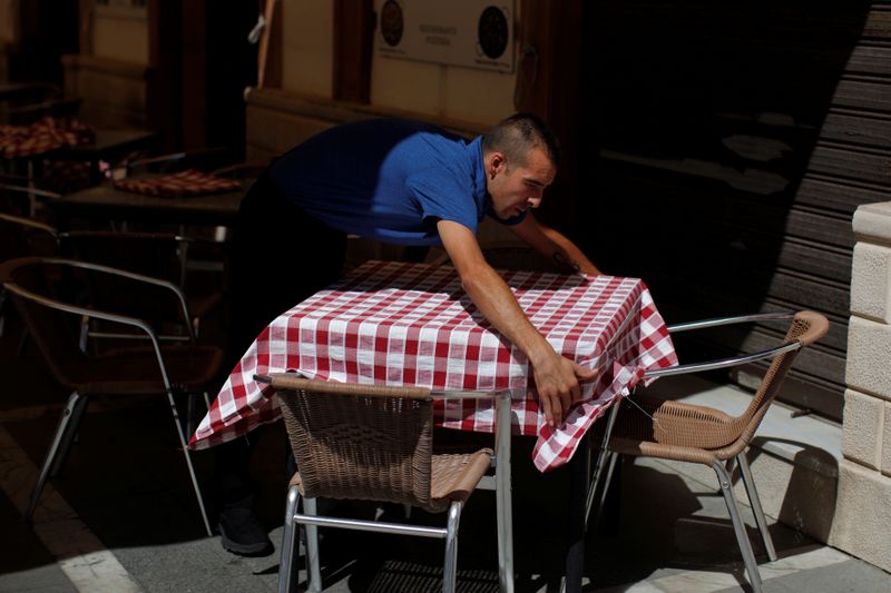 &copy; Reuters. Un camarero arregla un mantel en la terraza de un restaurante en el centro de Ronda