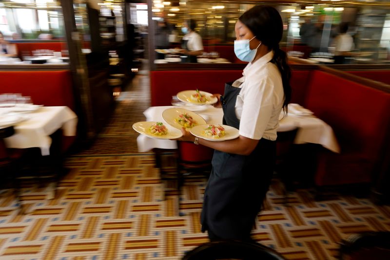&copy; Reuters. FILE PHOTO: A waiter serves dishes in a dining room at Au Petit Riche restaurant in Paris as cafes, bars and restaurants reopen indoor dining rooms in France, June 9, 2021. REUTERS/Pascal Rossignol/File Photo