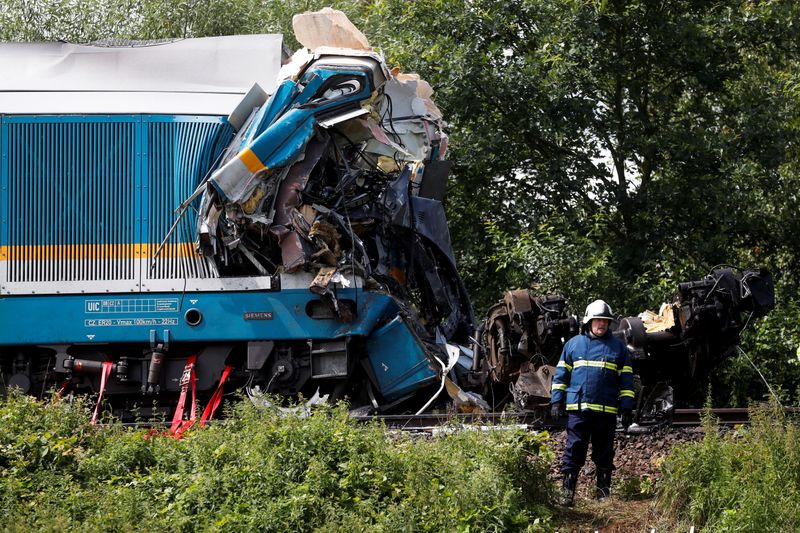 © Reuters. أحد العاملين في الطوارئ يعمل في موقع تصادم قطارين بالقرب من بلدة دوماجليتسه في التشيك يوم الأربعاء. تصوير: ديفيد سيرني - رويترز