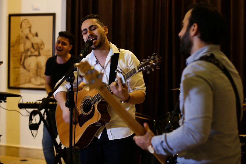 &copy; Reuters. المحاسب الفلسطيني راجي الجرو يغني ويعزف الجيتار أثناء تمرين لفرقة (أوسبري في) أول فرقة لموسيقى الروك في مدينة غزة في الأول من أغسطس آب 2021. تص