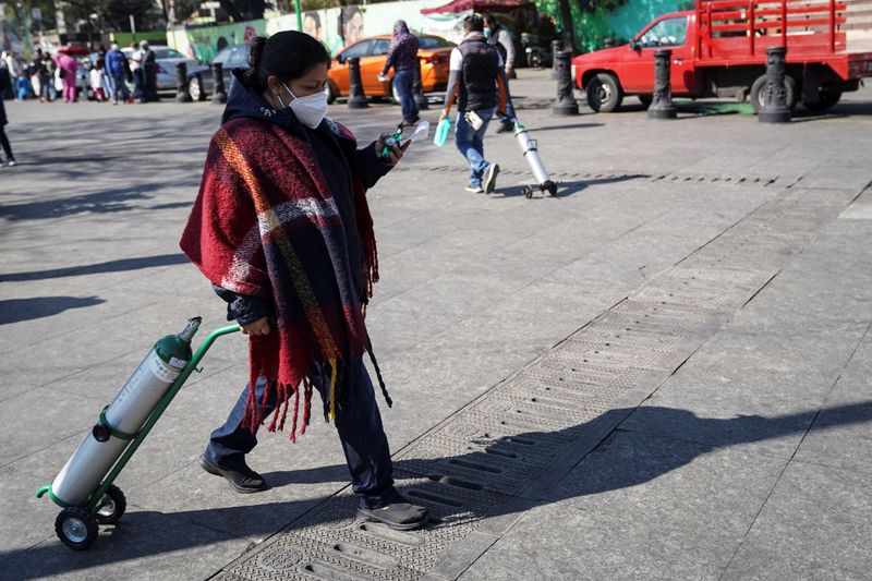 &copy; Reuters. FOTO DE ARCHIVO-Personas llevan tanques de oxígeno para sus familiares infectados con la enfermedad del coronavirus (COVID-19), como parte del programa de recarga gratuita del gobierno de la ciudad, en la alcaldía de Iztapalapa, en la Ciudad de México,