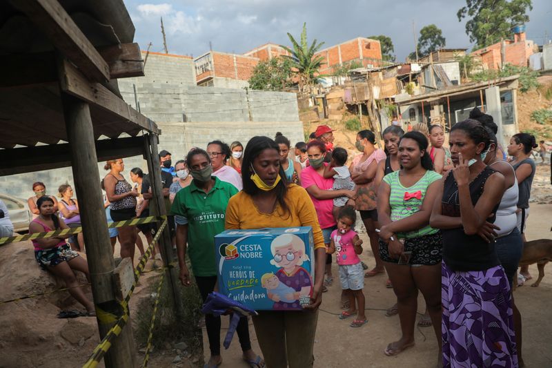 &copy; Reuters. Mulher carrega caixa de doações de alimentos na favela da Capadócia, em São Paulo
01/05/2020
REUTERS/Amanda Perobelli