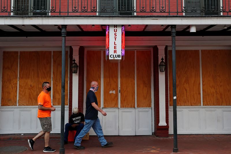 &copy; Reuters. FILE PHOTO: Men wearing protective face masks walk by a a closed Larry Flynt's Hustler Strip Club, amid the coronavirus disease (COVID-19) outbreak, along Bourbon Street in the French Quarter in New Orleans, Louisiana, U.S. August 30, 2020. REUTERS/Shanno