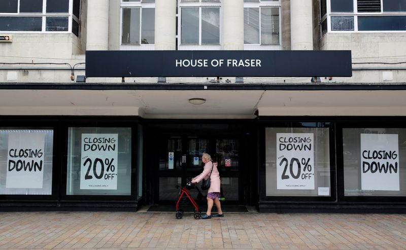 &copy; Reuters. FILE PHOTO: A woman walks past a House of Fraser store, a retail chain owned by Mike Ashley's Sports Direct, ,that has closing down posters in the windows, in Hull, Britain July 4, 2019. REUTERS/Russell Boyce