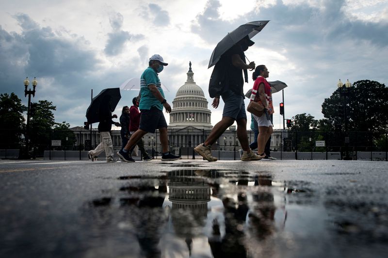 &copy; Reuters. Alcuni turisti davanti a una recinzione di sicurezza che circonda il Campidoglio degli Stati Uniti a Washington, USA, 9 luglio 2021. REUTERS/Alexander Drago 
