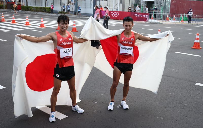 © Reuters. 　８月５日、東京五輪は男子２０キロ競歩を行い、池田尚希が１時間２１分１４秒で銀メダル、山西利和が１時間２１分２８秒で銅メダルを獲得した。写真はメダルを喜ぶ池田（左）と山西。札幌市で撮影（２０２１年　ロイター/Kim Hong-Ji）