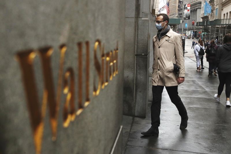 © Reuters. FILE PHOTO: A man wears a protective mask as he walks on Wall Street during the coronavirus outbreak in New York City, New York, U.S., March 13, 2020. REUTERS/Lucas Jackson/File Photo