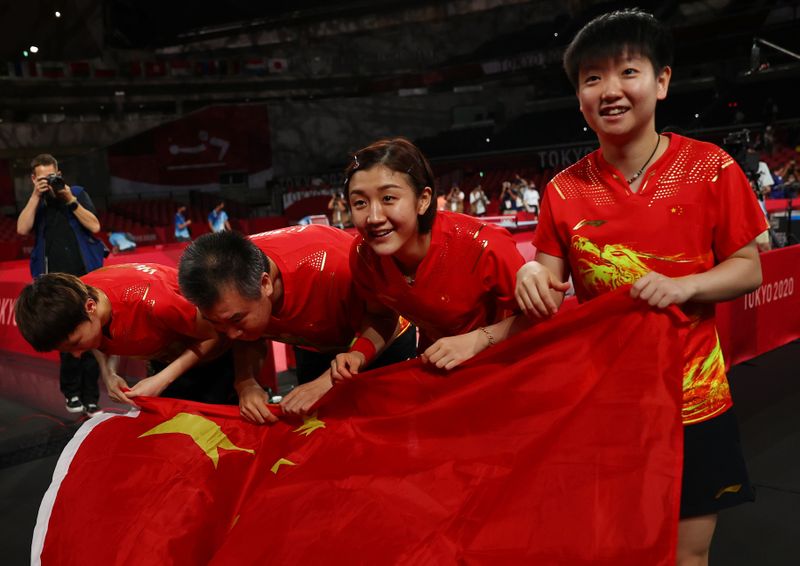 &copy; Reuters. الفريق الصيني المؤلف من تشين مينغ وسون ينغشا ووانغ مانيو يحتفل بالفوز بذهبية فرق السيدات في تنس الطاولة في ألعاب طوكيو يوم الخميس. صورة لروي