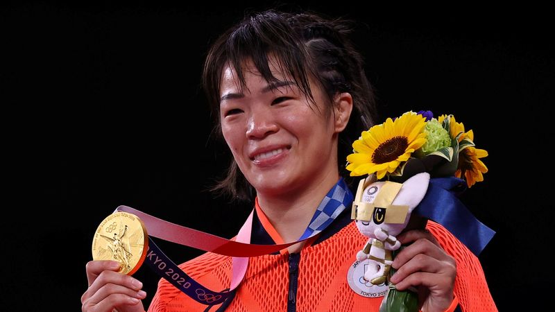 © Reuters. اليابانية ريساكو كاواي تحتفل بالفوز بذهبية وزن الخفيف للسيدات في المصارعة الحرة في ألعاب طوكيو يوم الخميس. تصوير: ليا ميليس - رويترز.
