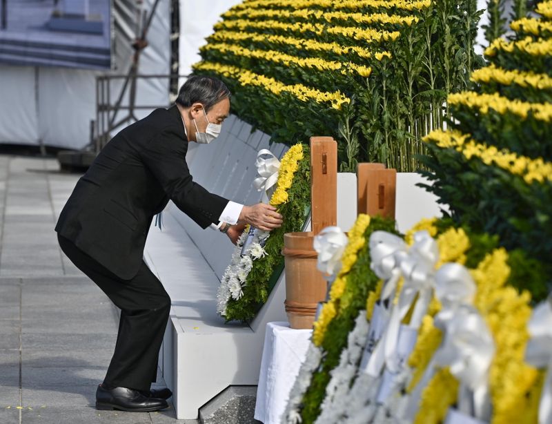 &copy; Reuters. Japan's Prime Minister Yoshihide Suga wearing a protective face mask, places a wreath on the cenotaph for the victims on the 76th anniversary of the world's first atomic bombing in Hiroshima, Japan, August 6, 2021. Mandatory credit Kyodo/via REUTERS   