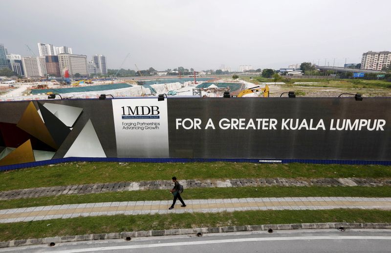 &copy; Reuters. A man walks past a 1 Malaysia Development Berhad (1MDB) billboard at the funds flagship Tun Razak Exchange development in Kuala Lumpur, March 1, 2015.     REUTERS/Olivia Harris/File Photo