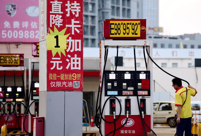 &copy; Reuters. A pump attendant is seen next to a discount advertisement for gasolines at a Petrochina petrol station in Shenyang, Liaoning province, China June 24, 2019.  REUTERS/Stringer  