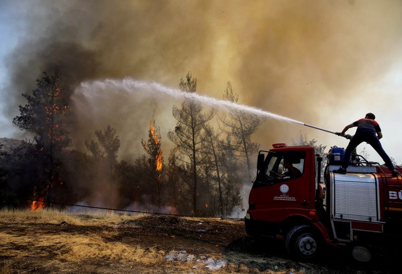 © Reuters. رجل إطفاء يحاول إخماد نيران حريق مشتعل في غابة قرب مرماريس في تركيا في أول أغسطس آب 2021. تصوير: أوميت بكطاش - رويترز.