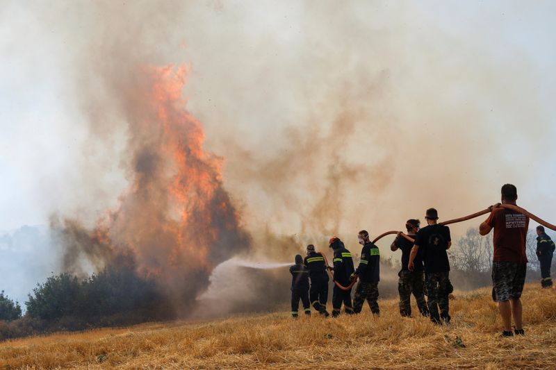&copy; Reuters. 記録的な熱波で山火事の発生が相次いでいるギリシャで６日、数千人の住民が避難を余儀なくされ、南部のペロポネソス半島や首都アテネ近郊のエビア島など全土の５６カ所で消火活動が行