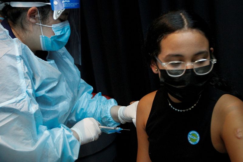 &copy; Reuters. FILE PHOTO: A girl is inoculated against the coronavirus disease (COVID-19) during a vaccination event hosted by Miami-Dade County and Miami Heat, at FTX Arena in Miami, Florida, U.S., August 5, 2021. REUTERS/Marco Bello