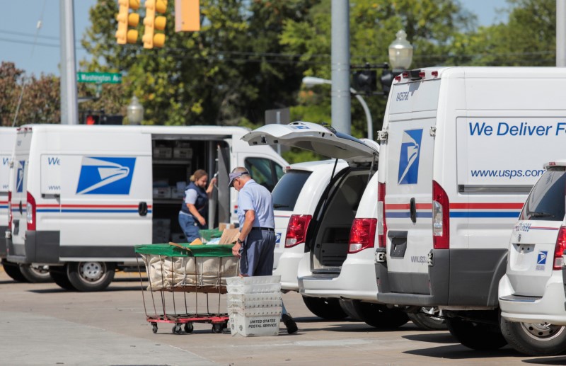 © Reuters. United States Postal Service (USPS) workers load mail into delivery trucks outside a post office in Royal Oak, Michigan, U.S. August 22, 2020. REUTERS/Rebecca Cook