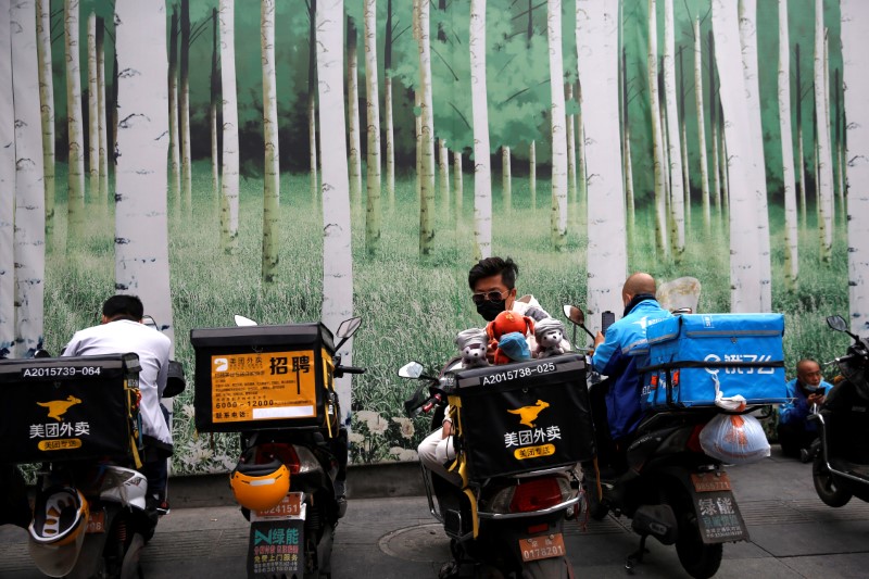 © Reuters. Delivery workers of Meituan and Ele.me wait for online orders at a shopping area in Beijing, as the spread of the novel coronavirus disease (COVID-19) continues, China April 15, 2020. REUTERS/Tingshu Wang