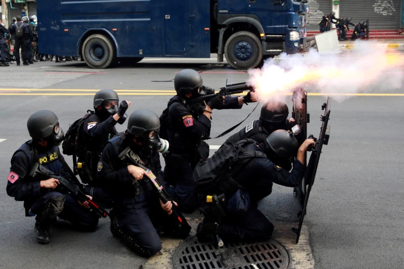 &copy; Reuters. شرطي يطلق سلاحه خلال تصدي الشرطة التايلانية لمتظاهرين يحتجون على ما يصفونه بإخفاق الحكومة في التعامل مع جائحة فيروس كورونا في بانكوك يوم ال