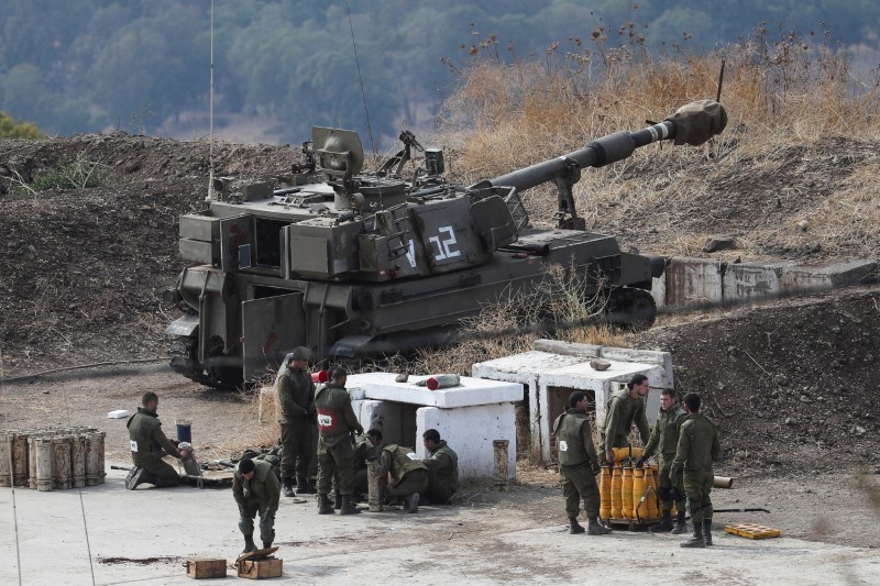&copy; Reuters. جنود إسرائيليون يقفون بجوار وحة مدفعية على الجانب الإسرائيلي من الحدود مع لبنان يوم الجمعة. تصوير: عمار عوض - رويترز.
