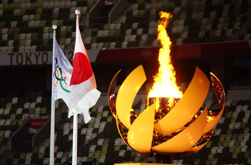 &copy; Reuters. 　8月８日、  異例の無観客開催となった東京五輪は、猛暑の中で行われた１７日間の熱戦が閉幕する。写真は国立競技場に灯された聖火。７月２３日撮影（２０２１年　ロイター/Kai Pfaffenbac
