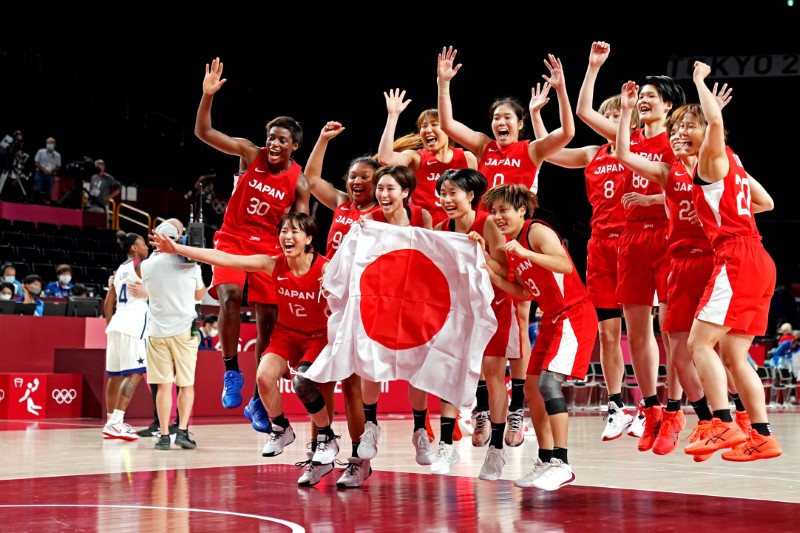 © Reuters. 　８月８日、日本の女子バスケットボール代表は東京五輪の決勝で米国に９０─７５で敗れ、銀メダルとなった。写真は銀メダルを獲得い、笑顔の日本チーム。さいたまスーパーアリーナで撮影（２０２１年　ロイター/Kyle Terada-USA TODAY Sports）