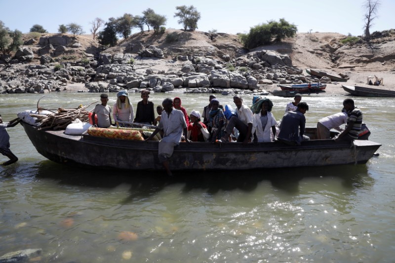 © Reuters. اثيوبيون فارون من اقليم تيجراي لدى وصولهم الى مخيم  الحمديات في السودان على متن قارب في الأول من ديسمبر كانون الأول 2020.تصوير: رويترز.