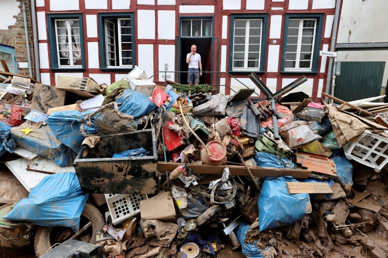 &copy; Reuters. FILE PHOTO: A man looks on outside a house in an area affected by floods caused by heavy rainfall in Bad Muenstereifel, Germany, July 19, 2021. REUTERS/Wolfgang Rattay/