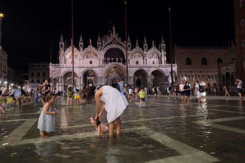 &copy; Reuters. La gente camina por una Plaza de San Marcos inundada durante una crecida excepcional en Venecia, Italia. 8 de agosto de 2021. REUTERS/Manuel Silvestri