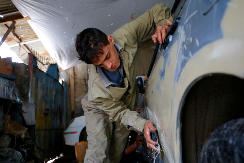&copy; Reuters. صبي يعمل في إصلاح سيارة بورشة في صنعاء يوم الرابع من أغسطس آب 2021 - رويترز
