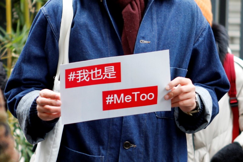 &copy; Reuters. FILE PHOTO: A protester holds a #MeToo sign outside a court before a sexual harassment case involving a Chinese state TV host, in Beijing, China December 2, 2020. REUTERS/Florence Lo/File Photo