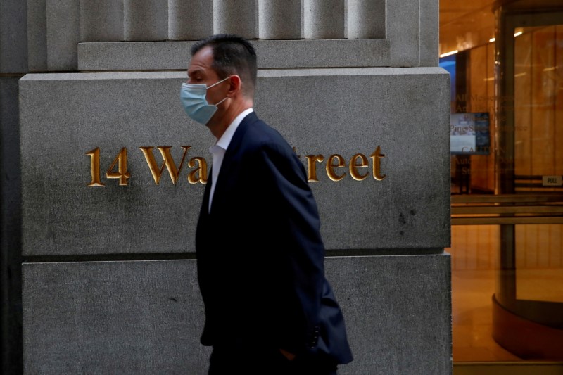 &copy; Reuters. FILE PHOTO: A man wearing a protective face mask walks by 14 Wall Street in the financial district of New York, U.S., November 19, 2020. REUTERS/Shannon Stapleton  