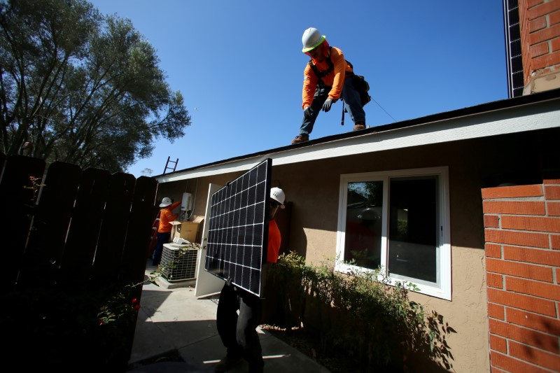 &copy; Reuters. FILE PHOTO: Workers lift a solar panel onto a roof during a residential solar installation in Scripps Ranch, San Diego, California, U.S. October 14, 2016. REUTERS/Mike Blake/File Photo