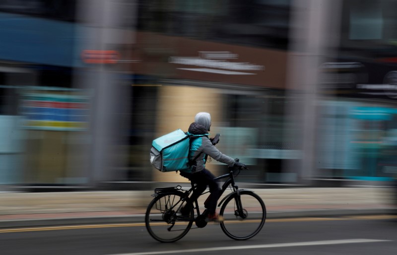 &copy; Reuters. FILE PHOTO: A deliveroo delivery driver cycles through the centre of Manchester, Britain, March 8, 2021. REUTERS/Phil Noble