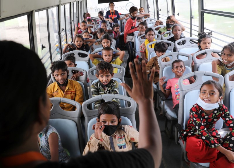&copy; Reuters. A woman teaches children inside a parked bus run by TejasAsia, an NGO using "Hope" buses as mobile classrooms for children living in slums, on the floodplains of the Yamuna river in New Delhi, India August 9, 2021. REUTERS/Anushree Fadnavis