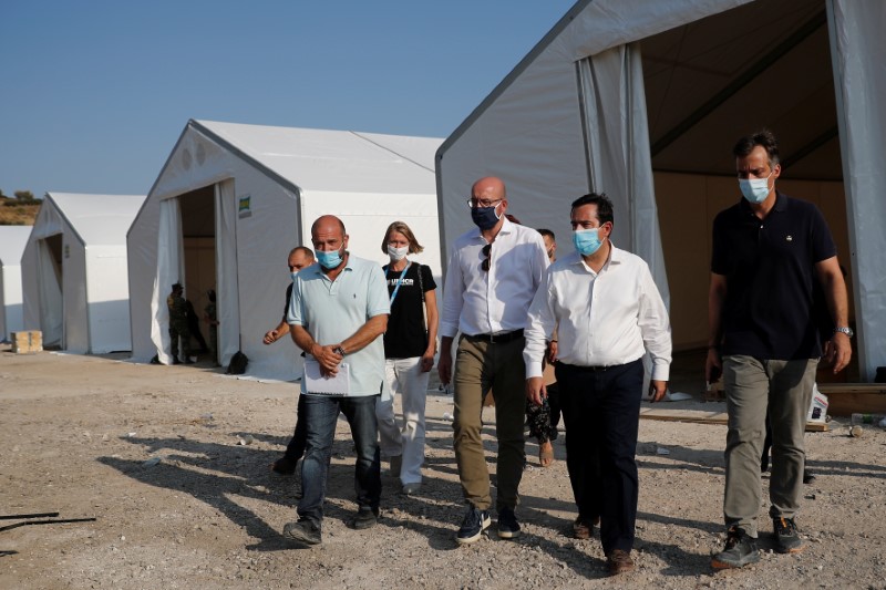 © Reuters. وزير الهجرة اليوناني نوتيس ميتاراتشي ومعه رئيس المجلس الأوروبي شارل ميشيل يتفقدان مخيما مؤقتا للاجئين. رويترز