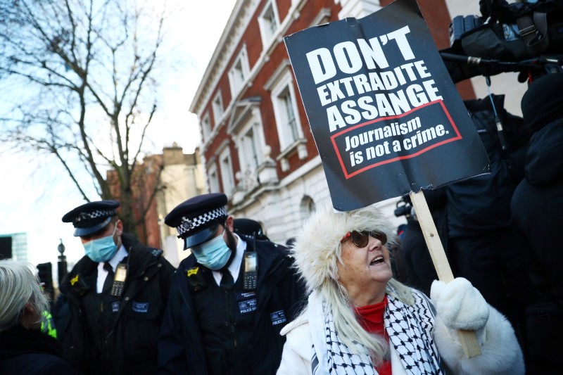 &copy; Reuters. مؤيدة لمؤسس موقع ويكيليكس جوليان أسانج ترفع لافتة ادعو لعدم تسليمه في لندن يوم 6 يناير كانون الثاني 2021. رويترز