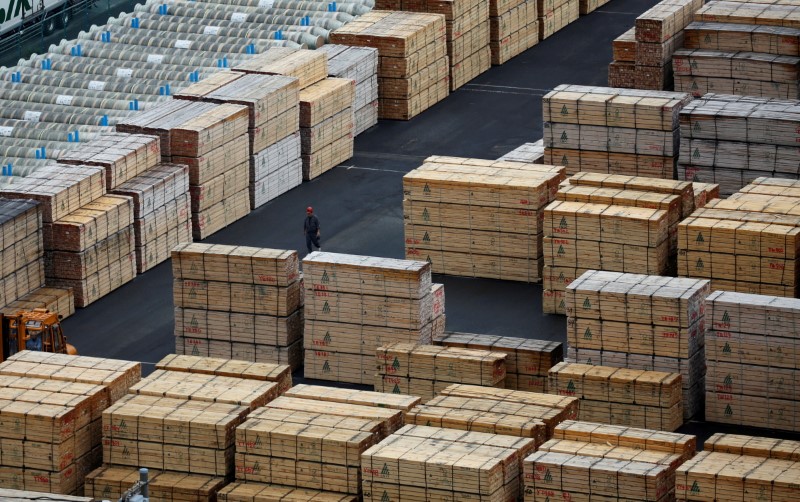 © Reuters. FILE PHOTO: A worker walks among processed timber at a port in Keihin industrial zone in Kawasaki, Japan, September 14, 2016. Picture taken September 14, 2016. REUTERS/Toru Hanai/File Photo