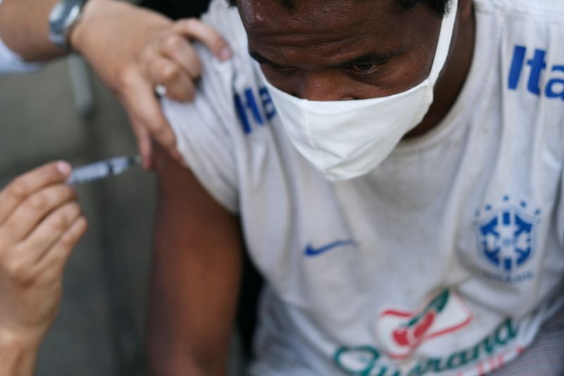 &copy; Reuters. Profissional de saúde aplica vacina contra Covid-19 em pessoa em situação de rua no centro do Rio de Janeiro
27/05/2021 REUTERS/Ricardo Moraes