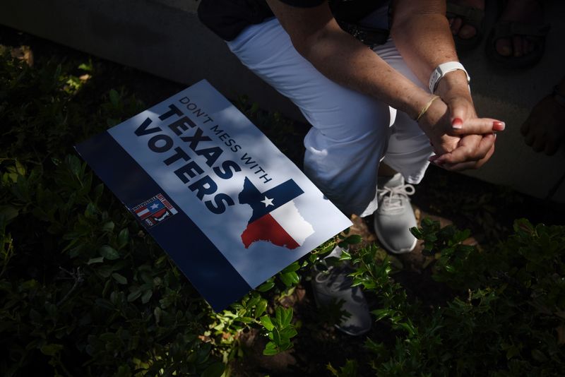 © Reuters. FILE PHOTO: A protester sits in the shade following a march for voting rights and against the state's efforts to enact voting restrictions in Austin, Texas, U.S., July 31, 2021.  REUTERS/Callaghan O'Hare