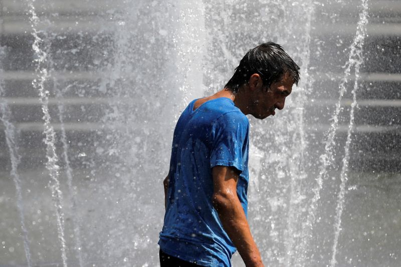 &copy; Reuters. A man walks in the fountain in Washington Square Park as a heat wave hit the region in Manhattan, New York City, U.S., August 12, 2021. REUTERS/Andrew Kelly
