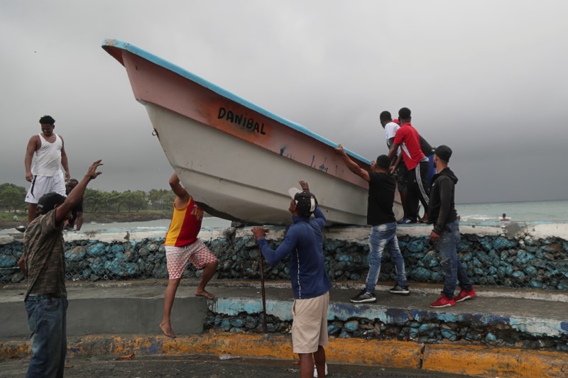 &copy; Reuters. IMAGEN DE ARCHIVO. Personas sacan un bote de la playa antes de la llegada de la tormenta tropical Fred en Santo Domingo, República Dominicana, Agosto 11, 2021. REUTERS/Ricardo Rojas 