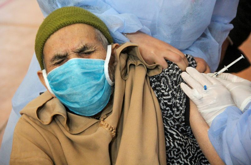 © Reuters. رجل يحصل على تطعيم ضد كوفيد-19 في سلا بالمغرب يوم 29 يناير كانون الثاني 2021. تصوير: شيرين طلعت - رويترز. 
